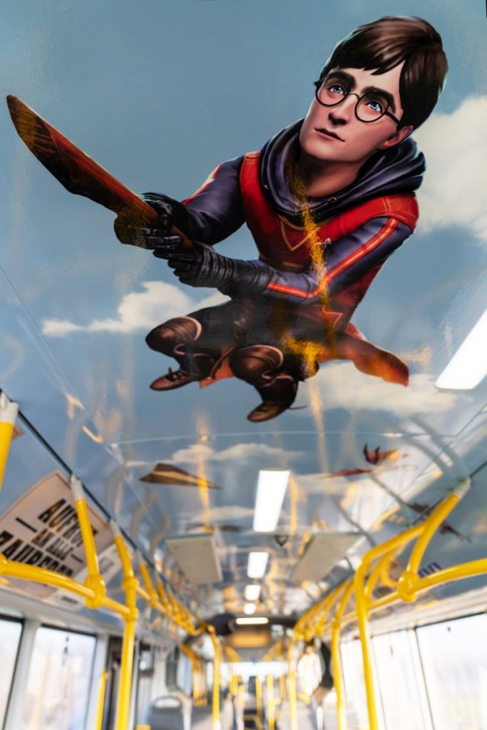Im Bus fliegt Harry Potter auf seinem Nimbus-Besen über die Köpfe der Fahrgäste
