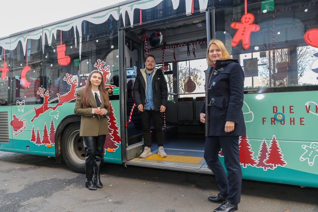 Die Auszubildenden Catalina Craciun (links) und Benjamin Schönherr zusammen mit VHH-Geschäftsführerin Nora Wolters vor dem Weihnachtsbus